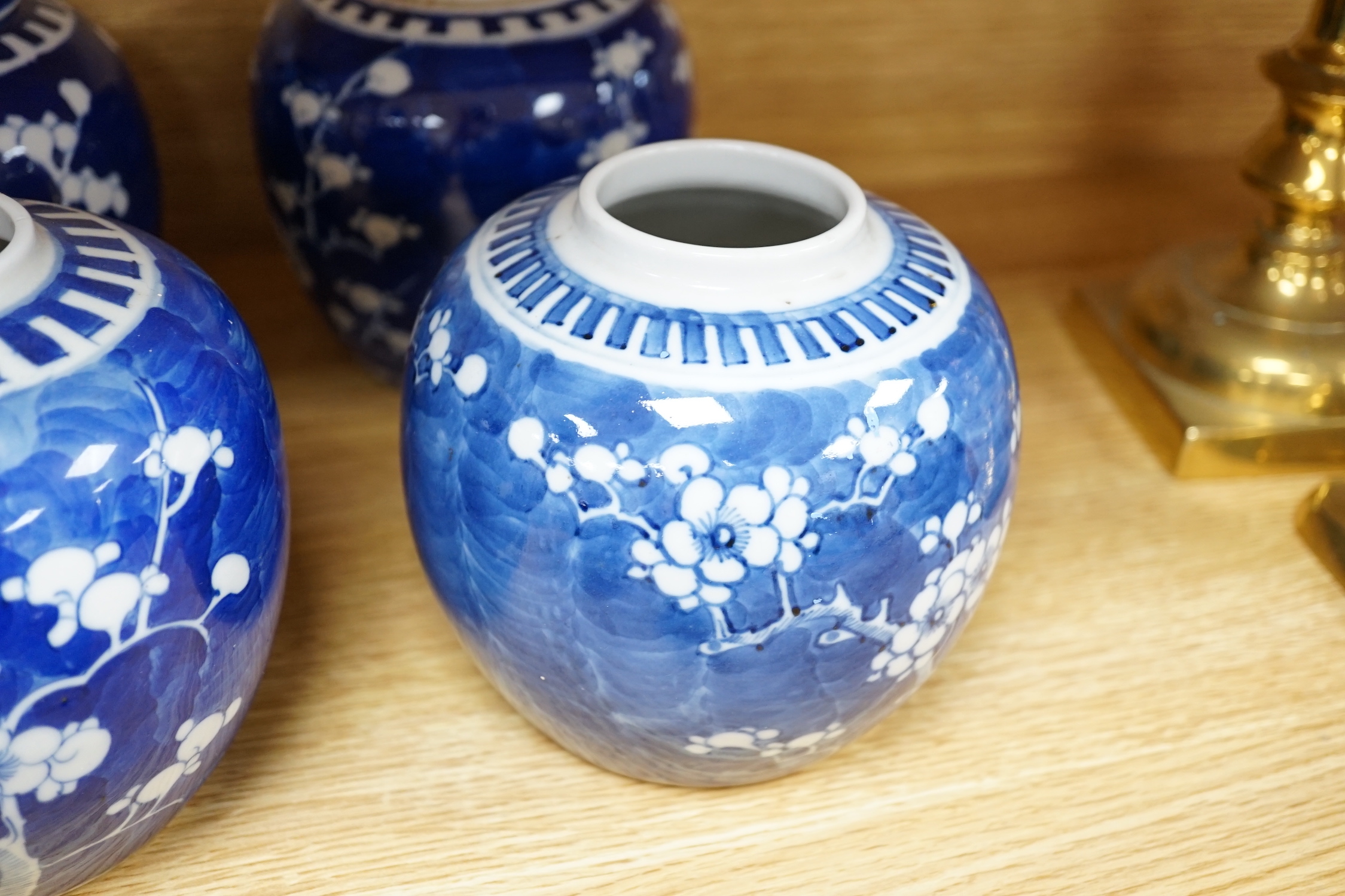 Five Chinese blue and white prunus ginger jars, one with cover- 15cm high and another jar